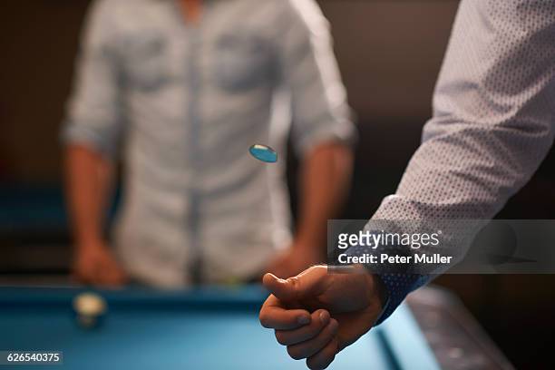 man tossing coin at pool table - flipping a coin stock pictures, royalty-free photos & images