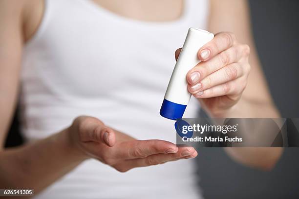 cropped shot of young woman holding tube of moisturiser - creme tube ストックフォトと画像