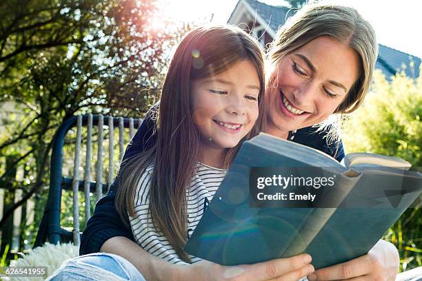 mother and daughter reading book - love books stock-fotos und bilder