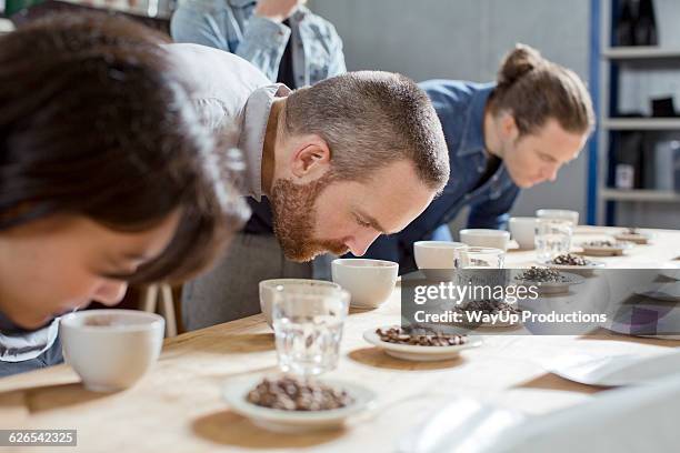 coffee tasters smelling cups of coffee - flavoring stock-fotos und bilder