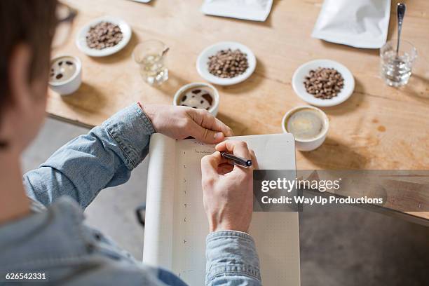 coffee taster writing notes - esperto foto e immagini stock