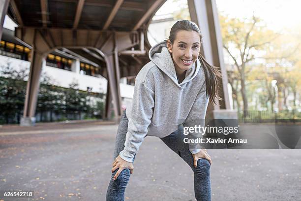 woman taking break after a run - inclinar se pose imagens e fotografias de stock