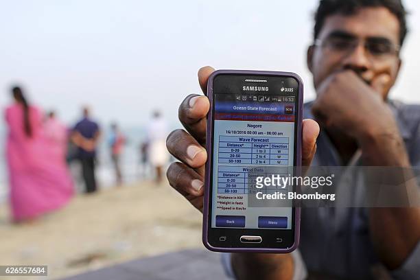 Fisherman displays the Ocean State Forecast app, a service provided by Earth System Science Organisation - Indian National Centre for Ocean...