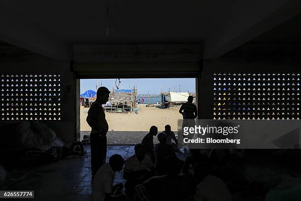 Fishermen are silhouetted as they take a break at Velankanni beach near Nagapattinam, Tamil Nadu, India, on Saturday, Oct. 15, 2016. Thousands of...