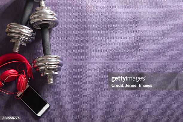 flat lay image of weights and smartphone on fitness mat. - multiple smart devices stock-fotos und bilder