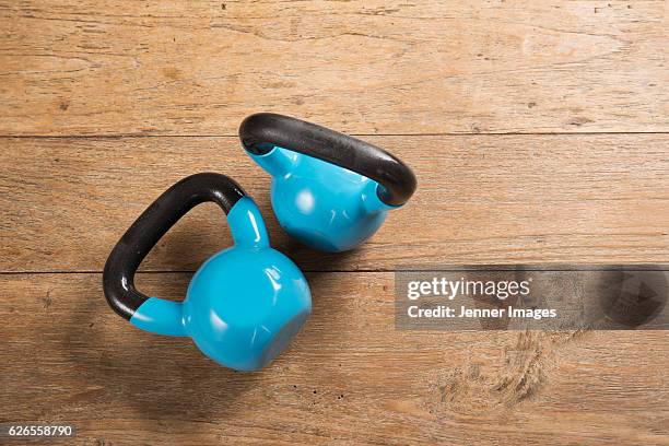 flat lay image of kettlebells on a wooden floor. - kugelhantel stock-fotos und bilder