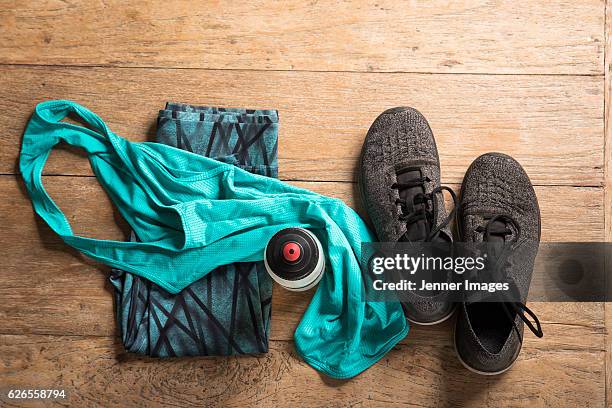 flat lay image of sports clothes and shoes on a wooden floor. - sportbekleidung stock-fotos und bilder