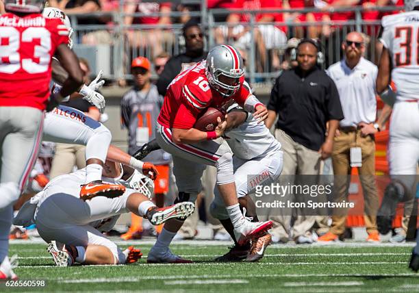Ohio State Buckeyes quarterback Joe Burrow slips through the defensive players for a first down during the game between the Bowling Green Falcons and...