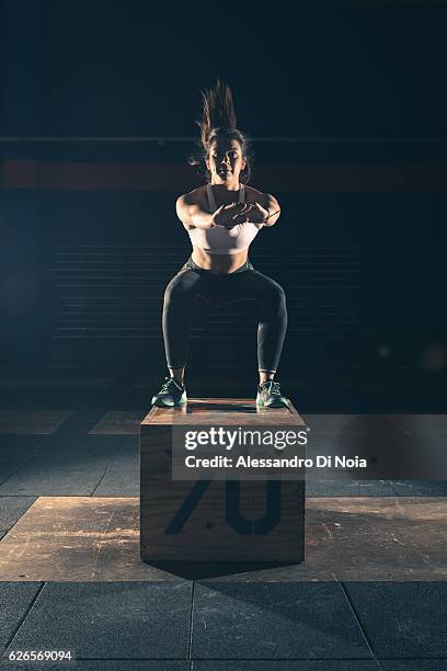 strong woman jump on a crate in a gym - inside of box stock pictures, royalty-free photos & images