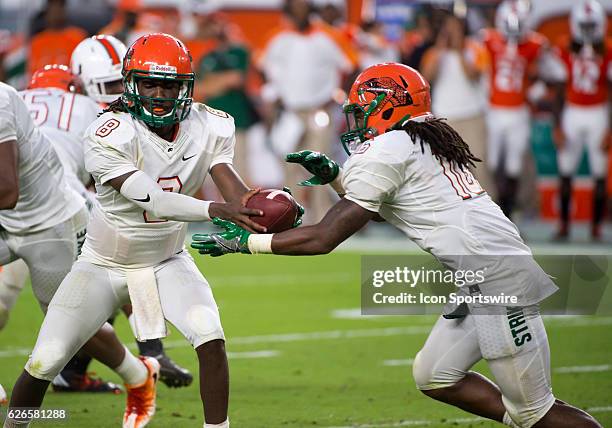 Florida A & M Rattlers Quarterback Kenneth Coleman hands off the ball to Florida A & M Rattlers Running Back Hans Supre during the NCAA football game...