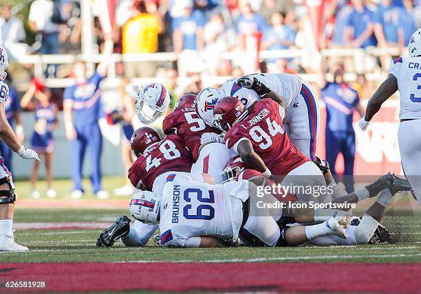 Louisiana Tech Bulldogs quarterback J'mar Smith's helmet flies in the air during a sack by Arkansas Razorbacks defensive lineman Deatrich Wise Jr. ,...