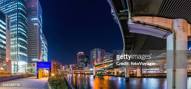 city highway curving through modern skyscrapers illuminated night osaka japan - osaka prefecture stock pictures, royalty-free photos & images