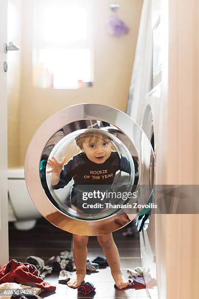 1 year old boy in front of washing machine - recycled coffee cup sculpture highlights affects of everyday waste stockfoto's en -beelden