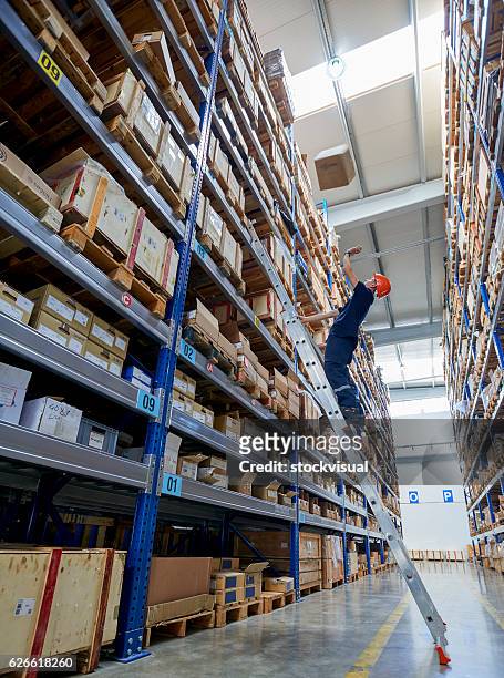man looking up at box falling on him, warehouse - bent ladder stock pictures, royalty-free photos & images