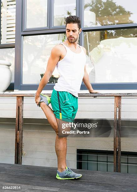 young man stretching leg in backyard - quadriceps muscle stock pictures, royalty-free photos & images