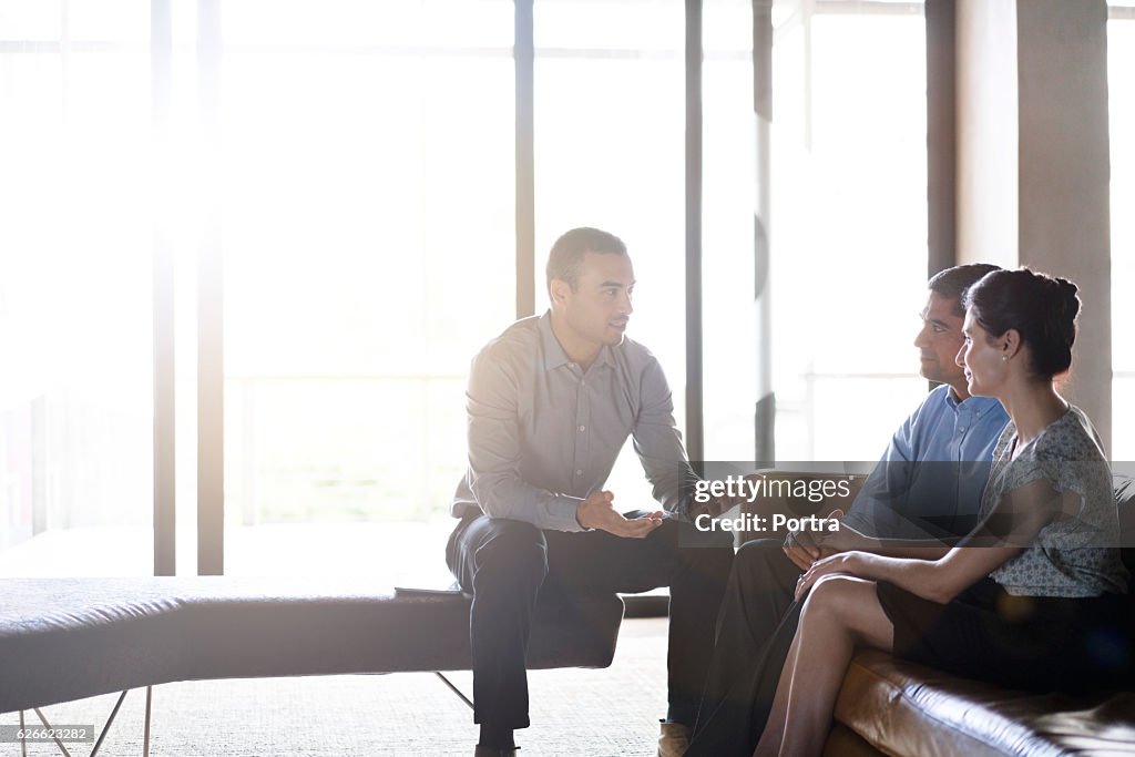 Financial planner talking with couple in office
