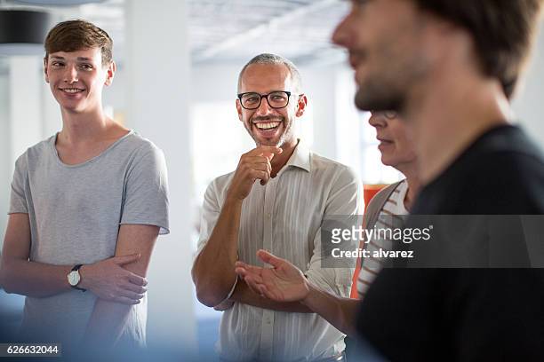 enjoying discussions in a stand up meeting - casual clothing stock pictures, royalty-free photos & images