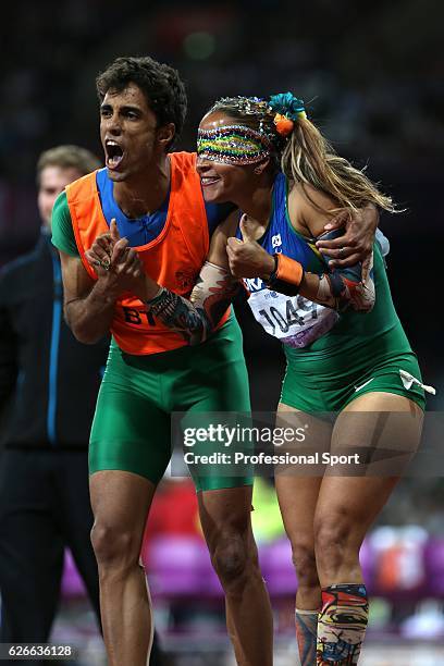 Terezinha Guilhermina of Brazil and her guide Guilherme Soares de Santana celebrate a victory and the gold medal in the Women's 100m - T11on day 7 of...