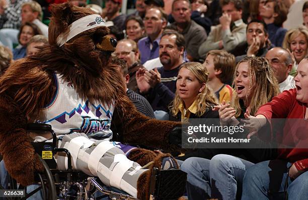 The Utah Jazz Mascot "Bear" greets some fans courtside while recovering from a torn ACL ligament in his knee at the Delta Center in Salt Lake City,...