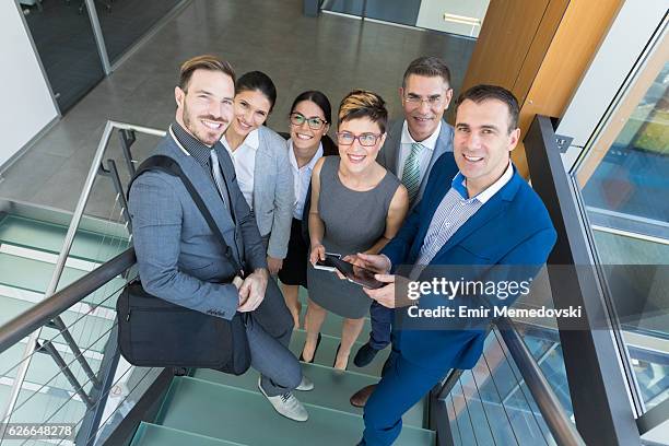 group of smiling business people standing on the staircase - portrait of young woman standing against steps stock pictures, royalty-free photos & images