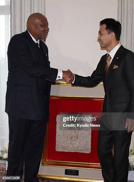 Visiting Lesotho King Letsie III shakes hands with Michio Umemoto, principal of the Stone for Peace Association of Hiroshima, as he receives a peace...