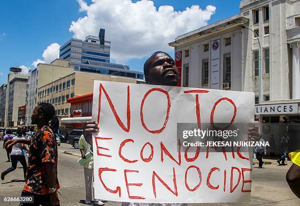 Protester holds a sign during a demonstration by opposition parties against the introduction of bond notes as a currency in Harare on November 30...