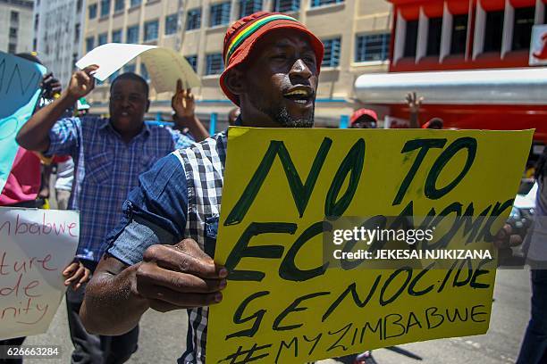 Protester holds a sign during a demonstration by opposition parties against the introduction of bond notes as a currency in Harare on November 30...