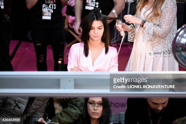 Model Kendall Jenner and US model Bella Hadid get ready backstage for the Victoria's Secret 2016 fashion show at the Grand Palais in Paris on...