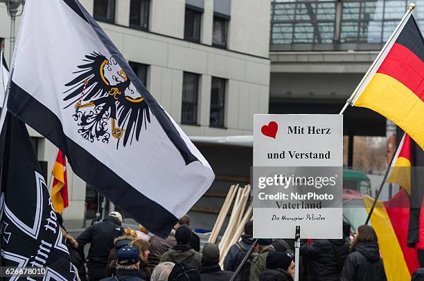 Supporters of the Pegida movement, in Berlin known by its local chapter as Baergida, carry flags and shoot anti-government slogan on November 26,...