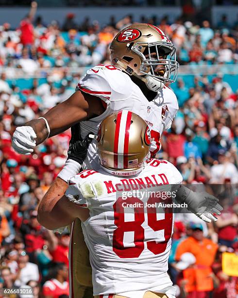 Carlos Hyde is congratulated by Vance McDonald of the San Francisco 49ers after scoring a touchdown against the Miami Dolphins on November 27, 2016...