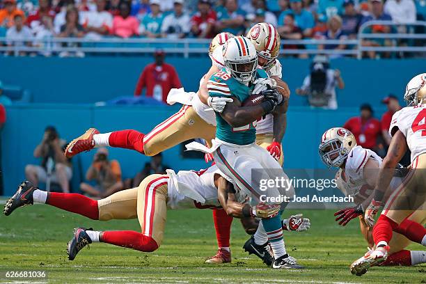 Damien Williams of the Miami Dolphins is tackled by Nick Bellore of the San Francisco 49ers as he runs with the ball on November 27, 2016 at Hard...