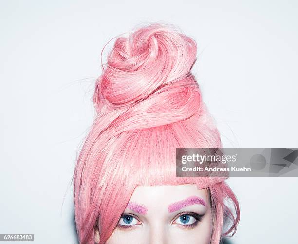 young woman with pink hair wig in an updo, crop. - haarkleuring stockfoto's en -beelden