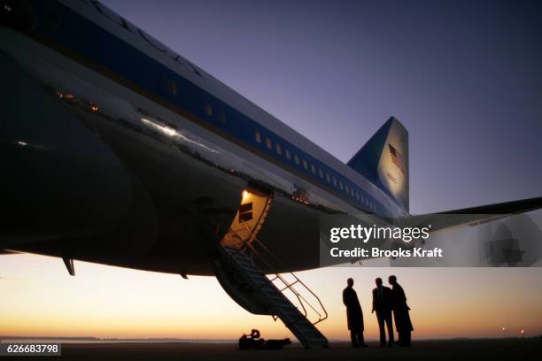 Air Force military personnel wait for the arrival of President Bush at the tail of Air Force One, before departure for a 4 day trip to Europe and the...