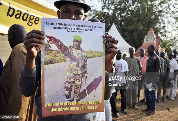 Protester holds a placard reading 'Injustice anywhere is a threat to justice everywhere' and 'When will there be a trial for the aggressors of the...