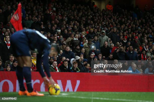 Arsenal fans take photos and also shout at Robin Van Persie of Manchester United as he prepares to take a corner kick