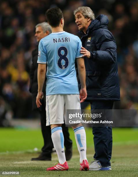 Manuel Pellegrini the head coach / manager of Manchester City talks to Samir Nasri of Manchester City before putting him on as a second half...