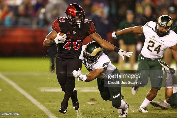 Running back Rashaad Penny of the San Diego State Aztecs is tackled by defensive back Braylin Scott of the Colorado State Rams in the first quarter...