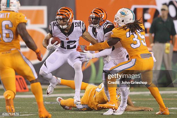 Alex Erickson of the Cincinnati Bengals runs the football upfield against Walt Aikens of the Miami Dolphins during their game at Paul Brown Stadium...