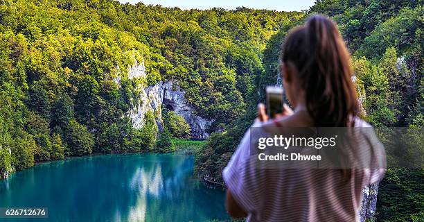 defocused of girl taking a picture of nature with smartphone - plitvice lakes national park stock pictures, royalty-free photos & images