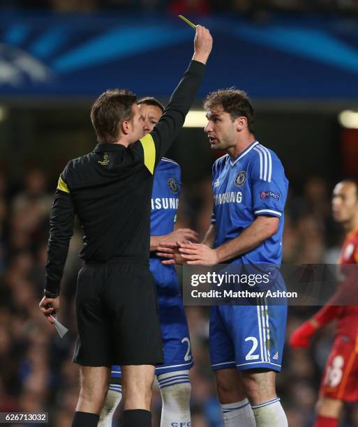 Branislav Ivanovic of Chelsea receives a yellow card from Referee Dr Felix Brych of Germany