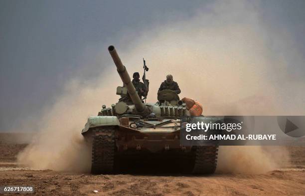 Iraqi Shiite fighters from the Hashed al-Shaabi paramilitaries drive a T-72 tank as they advance near the town of Tal Abtah, south of Tal Afar, on...