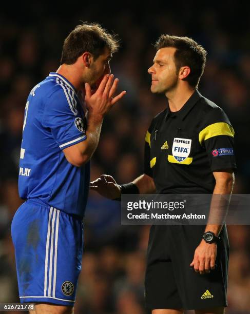 Branislav Ivanovic of Chelsea confronts referee Nicola Rizzoli of Italy after he awarded a second half penalty which resulted in Atletico Madrid...