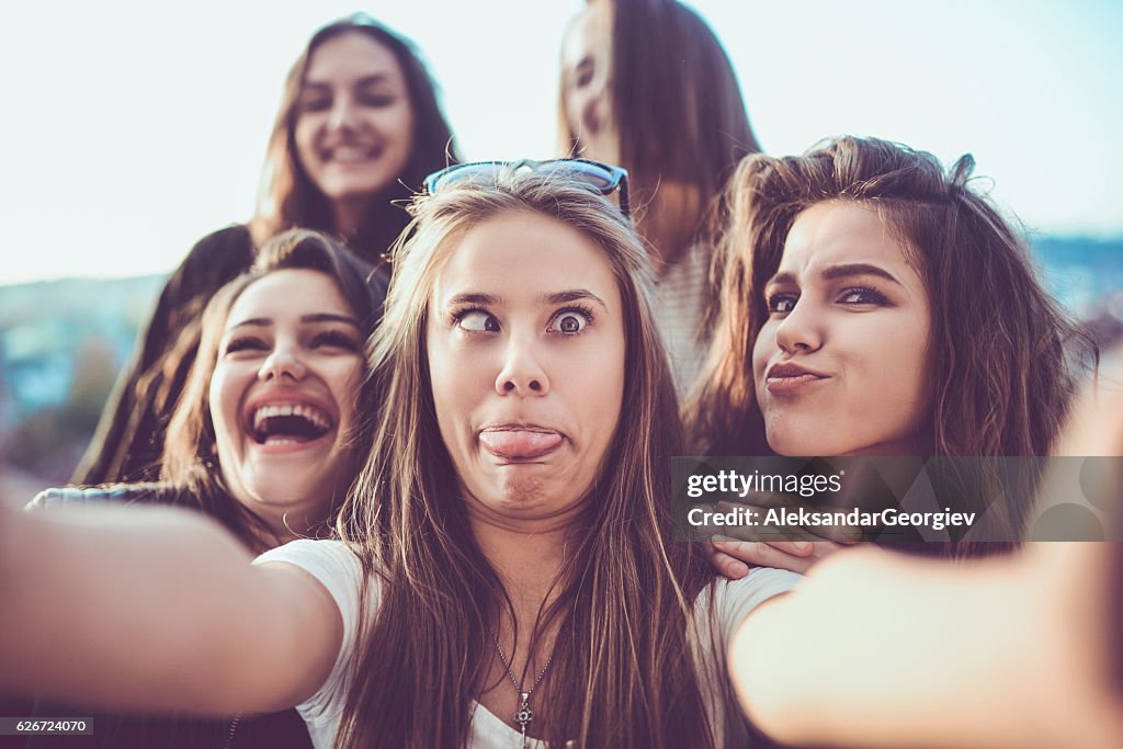 Gruppe von verrückten Mädchen, die Selfie und machen Gesichter im Freien
