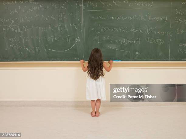 child prodigy looking at blackboard - child prodigy stock-fotos und bilder