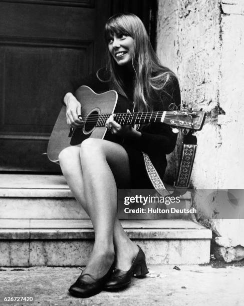 Singer called Joni. Joni Mitchell, Canadian singer-songwriter, United Kingdom, 1968. The guitar-pickin' gal is Joni Mitchell, a long blonde haired...