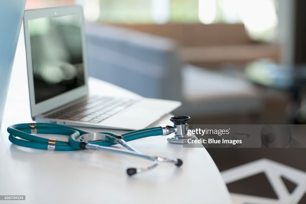 Laptop and stethoscope on desk