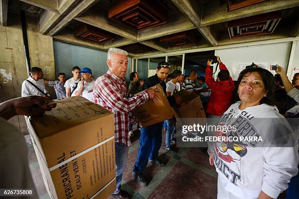 Opposition volunteers enter boxes with donations to the Dr. Jose Gregorio Hernandez Hospital at Catia neighbourhood in Caracas, on November 30, 2016....