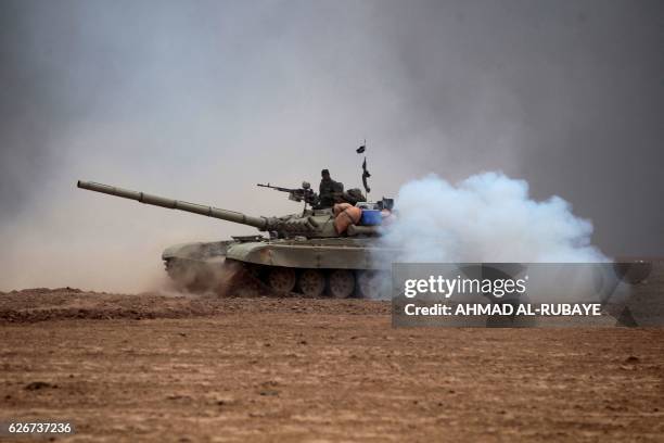 Iraqi Shiite fighters from the Hashed al-Shaabi paramilitaries manoeuver a T-72 tank as they advance near the town of Tal Abtah, south of Tal Afar,...