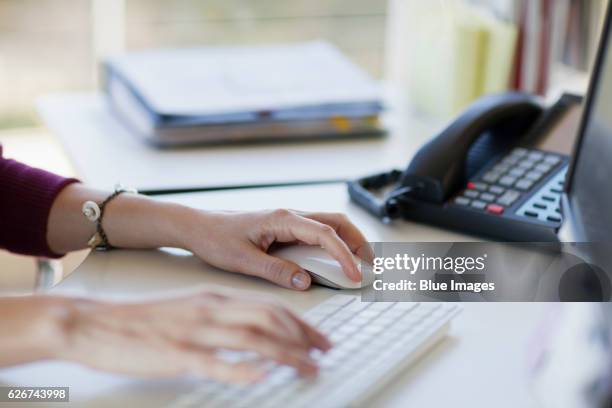 hands of woman using computer keyboard and mouse - hand on computer mouse stock pictures, royalty-free photos & images