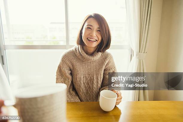 リビングルームでリラックスした女性 - 女性　日本人　笑顔　30代 ストックフォトと画像